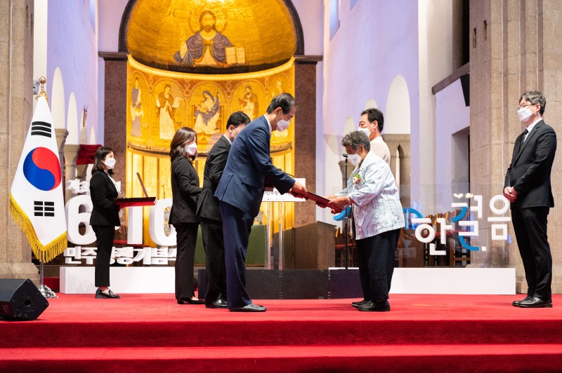 한덕수 국무총리가 민주발전 유공 훈장을 유가족에게 전수하고 있는 모습