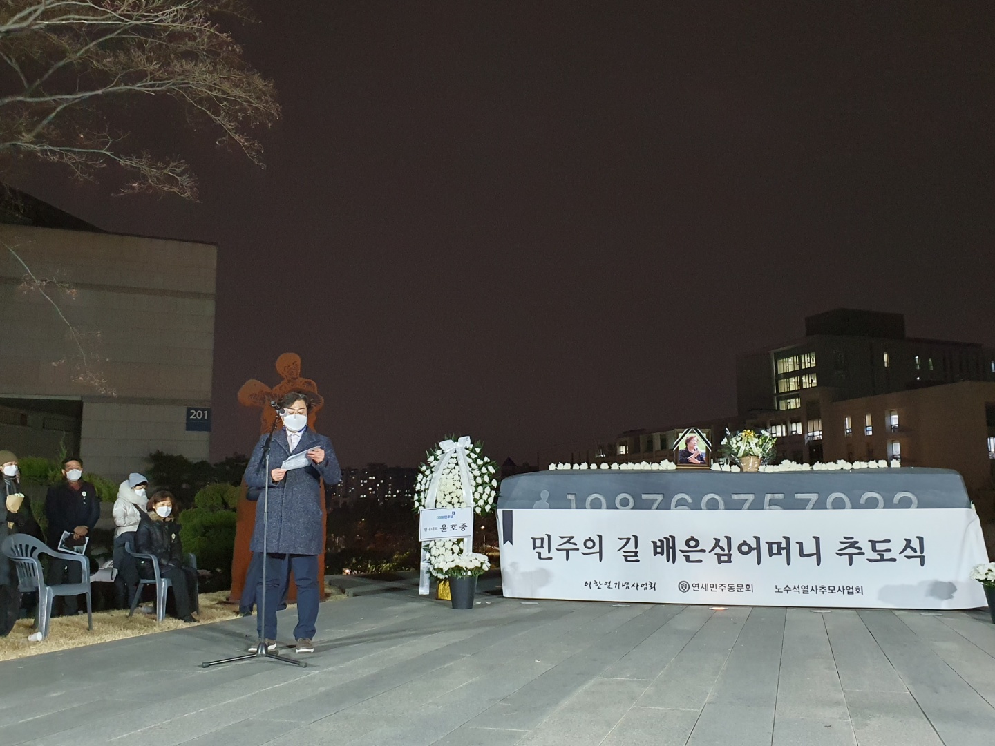 연세대학교 추도식에서 이원영 상임이사가 마이크 앞에 서서 추도사를 낭독하는 모습